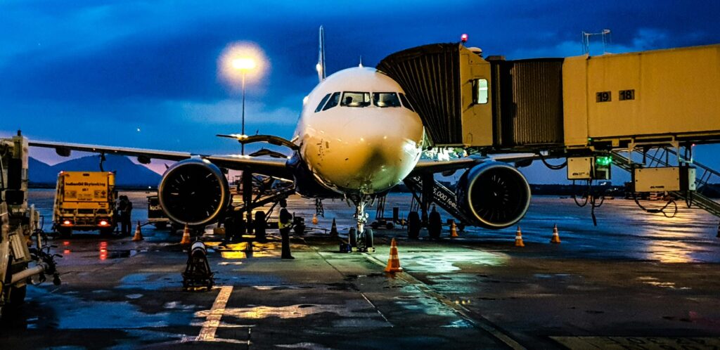 Ground handling crew marshalling an Airbus A320 at Kuwait International Airport at dusk